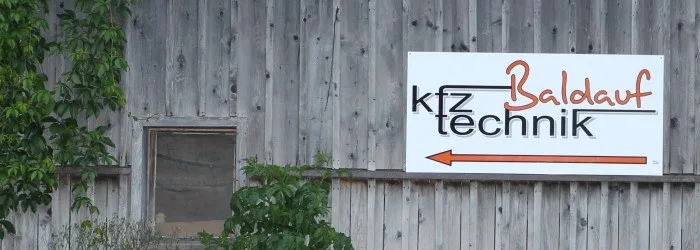 Wegweiser von kfz technik Baldauf am Werkstattgebäude