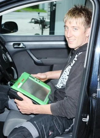 Markus Baldauf mit Diagnosegerät im Fahrzeug